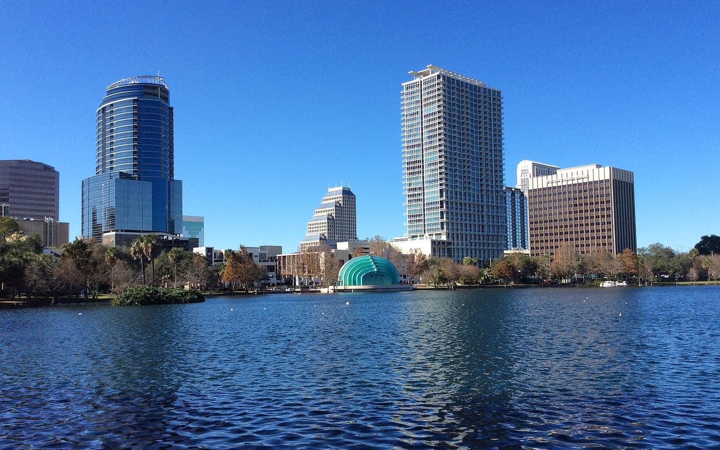 Lago Eola com os prédios do centro de Orlando ao fundo em dia de céu azul