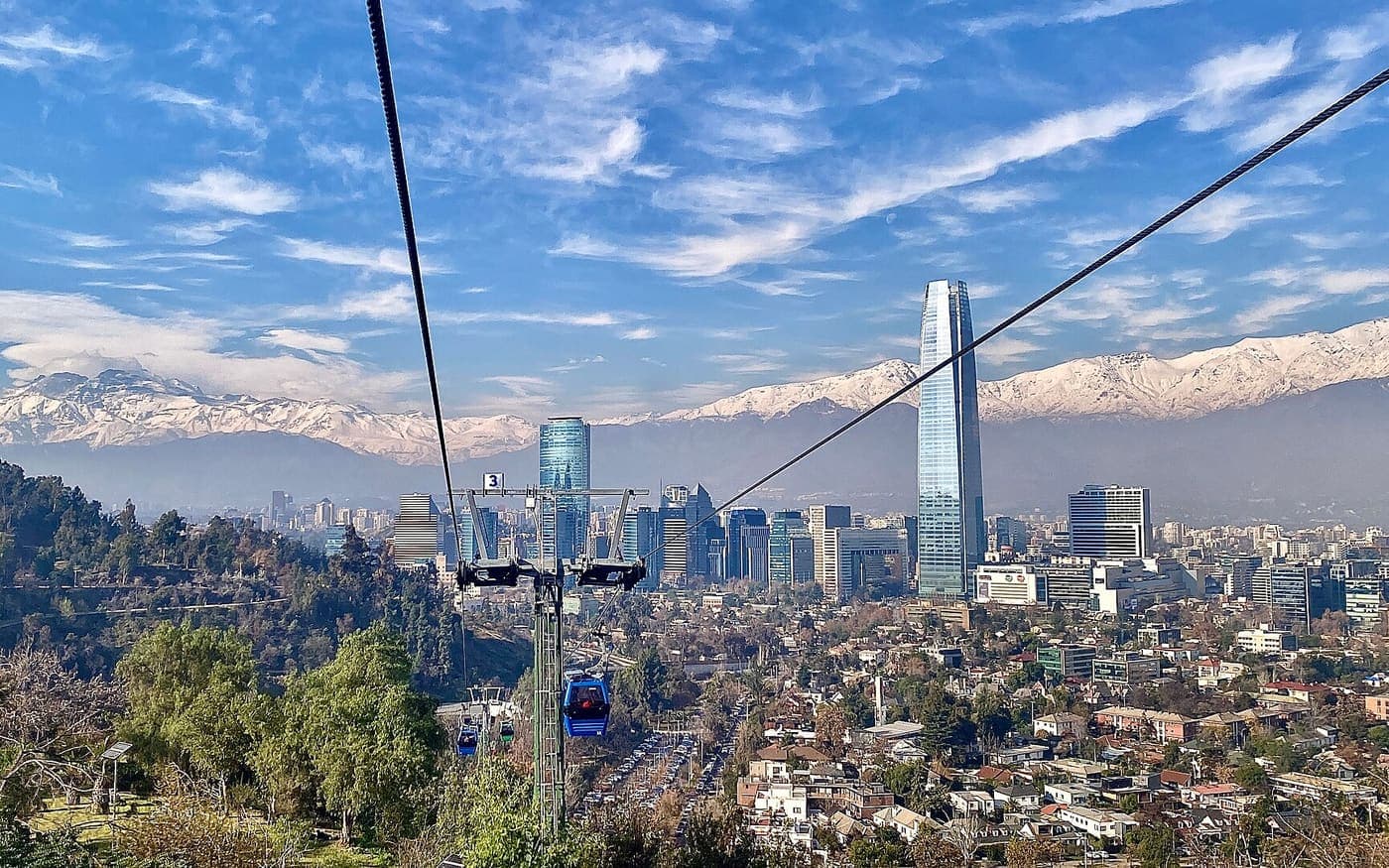 Prédios de Santiago do Chile com a Cordilheira dos Andes coberta de neve ao fundo